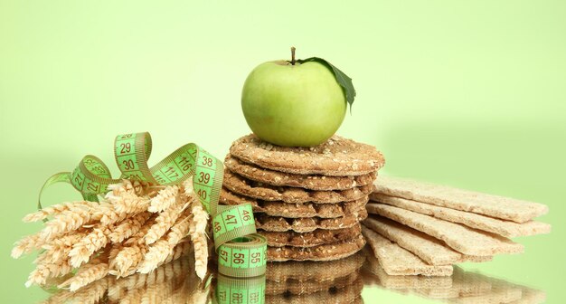 Foto smakelijke knäckebröd appel meetlint en oren op groene achtergrond