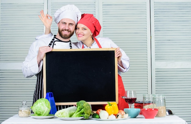 Smakelijke kookles Paar man en vrouw geven ok teken op bord in kookschool Meesterkok en prep kok geven kookles Chef-kok en kokhelper lesgeven masterclass kopieerruimte