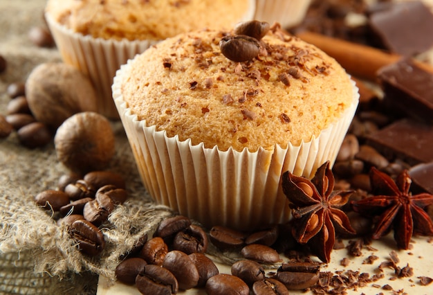 Smakelijke muffincakes met chocolade, kruiden en koffiezaden, op beige background