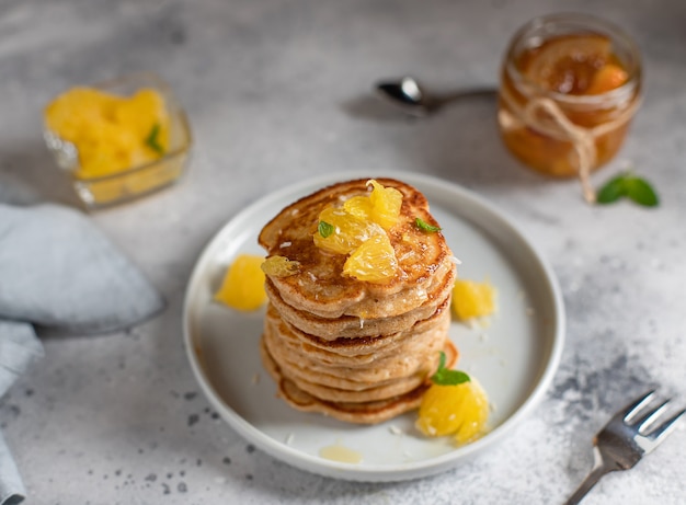 Smakelijke pannenkoeken geserveerd met oranje en jam grijze betonnen oppervlak