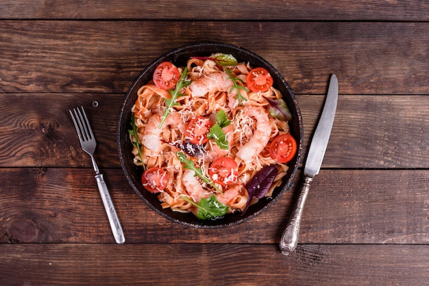 Smakelijke pasta met garnalen en tomaat op een koekenpan