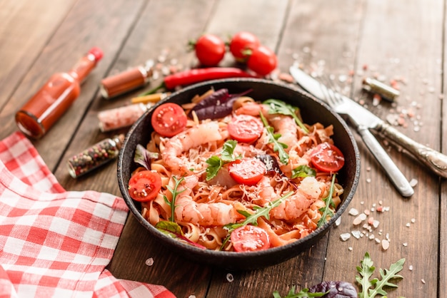 Smakelijke pasta met garnalen en tomaat op een koekenpan