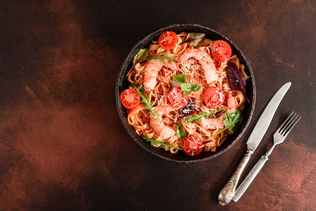 Smakelijke pasta met garnalen en tomaat op een koekenpan