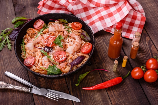 Smakelijke pasta met garnalen en tomaat op een koekenpan