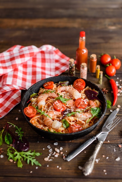 Smakelijke pasta met garnalen en tomaat op een koekenpan