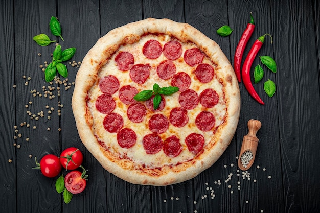 Smakelijke pepperonispizza en het koken van ingrediëntentomatenbasilicum