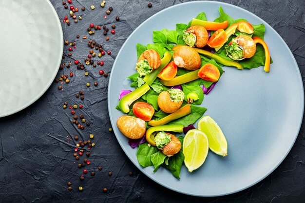 Smakelijke salade met spinazie, tomaat, peper en slakken.