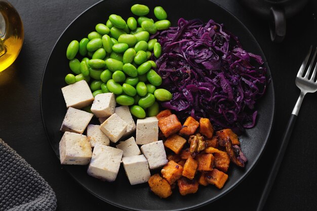 Smakelijke smakelijke veganistische kom met tofu op plaat. Bovenaanzicht