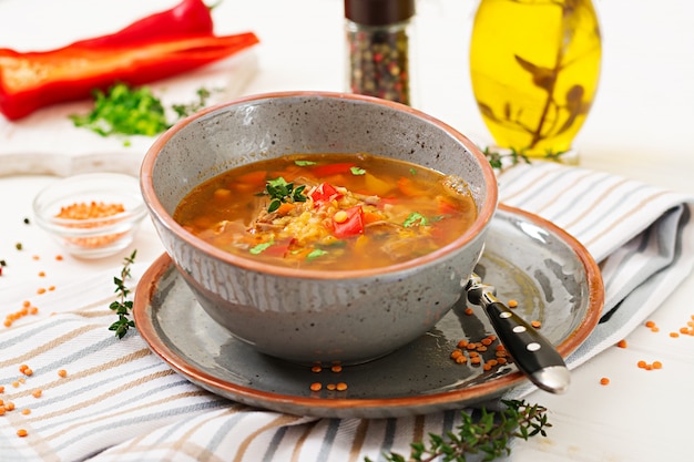 Smakelijke soep met rode linzen, vlees, rode paprika en geurige tijm