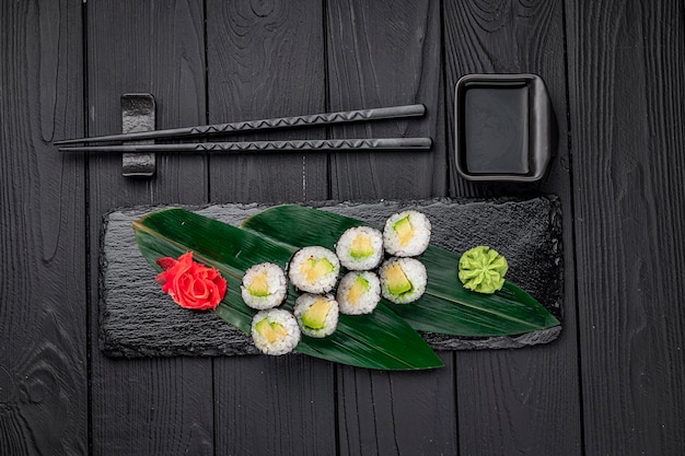 Smakelijke sushi maki roll op een zwarte stenen plaat