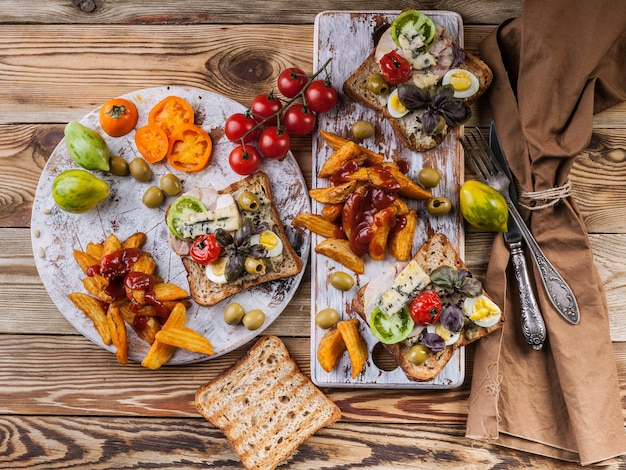 Smakelijke toast met avocado, kwarteleitjes, tomaten, Dor blauwe kaas en friet.