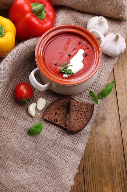 Smakelijke tomatensoep en groenten op houten tafel