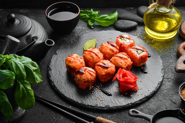 Smakelijke traditionele sushi-broodjes op een zwarte stenen plaat Japanse keuken Bovenaanzicht