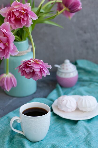 smakelijke traktatie. kopje koffie en een bord met marshmallows.