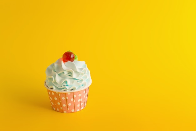 Smakelijke verjaardag cupcake op gele kleurenachtergrond.