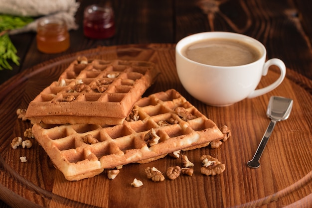 Smakelijke verse Wenen wafels, jam en kopje koffie op een donkere houten achtergrond