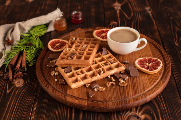 Smakelijke verse Wenen wafels, jam en kopje koffie op een donkere houten achtergrond