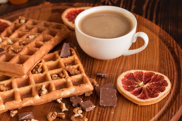 Smakelijke verse wenen wafels, jam en kopje koffie op een donkere houten achtergrond