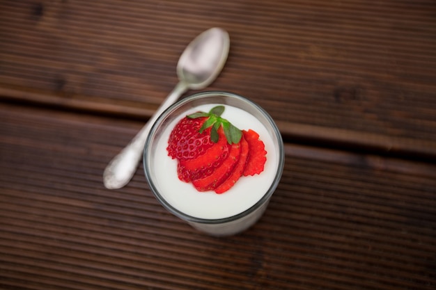 Smakelijke yoghurt met verse aardbeien op houten achtergrond