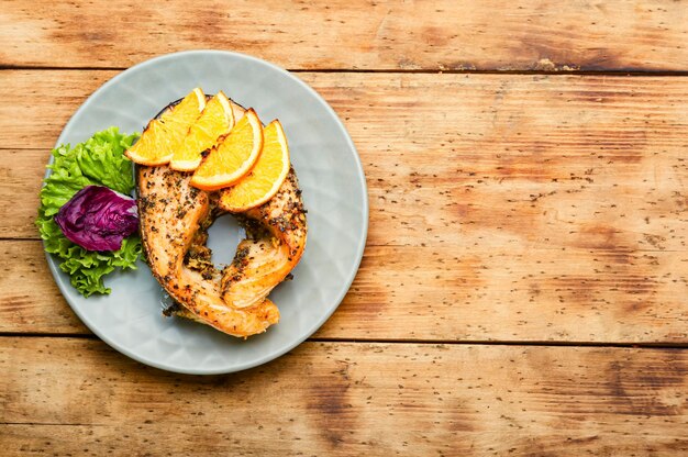 Smakelijke zalm steak gebakken met sinaasappels op plaat