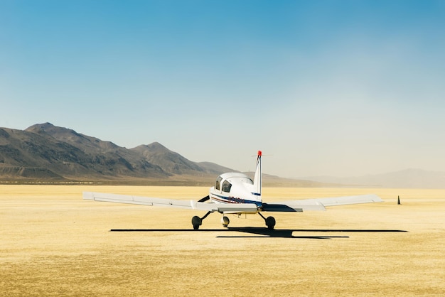 Small airplane in the desert with a blue sky and the sert all around, usa.