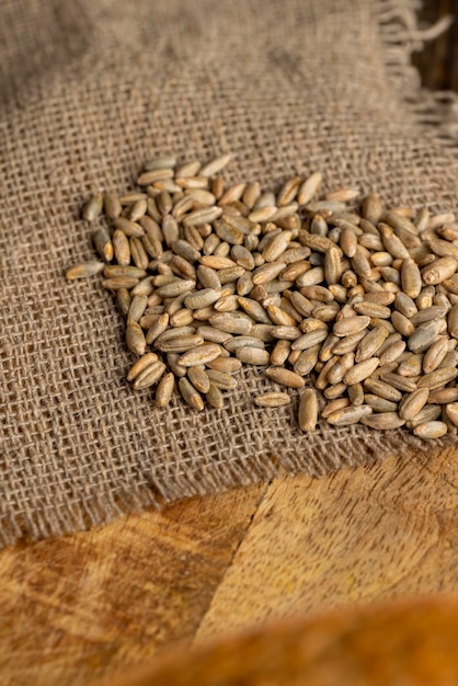 A small amount of rye grain which is used to prepare different types of dishes rye grains scattered on a wooden board