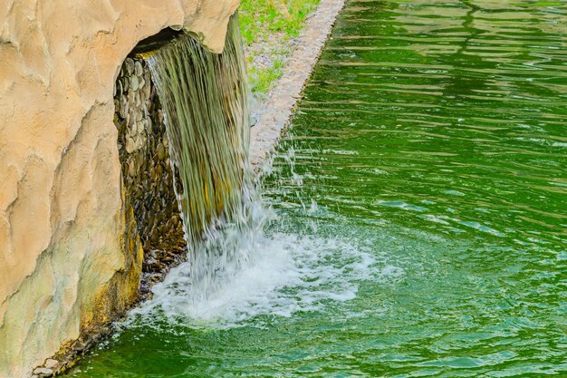 Foto piccola cascata artificiale in un giardino tropicale artificiale una piccola cascata decorativa nel giardino disegno paesaggistico