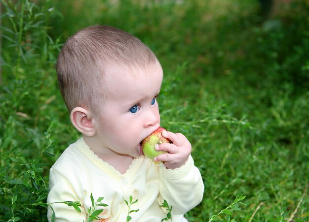 Small baby biting apple