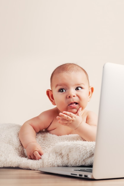 Small baby infant working playing learning on the laptop