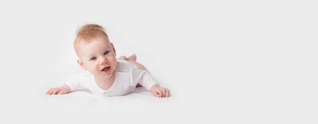 Small baby in white clothes on light , panoramic image