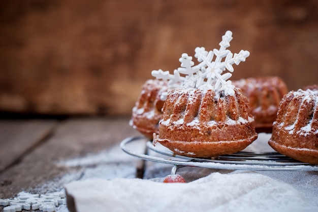Photo small baked cake decorated with white snowflakes and icing sugar