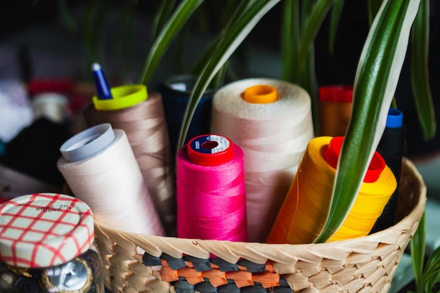 Small basket with bobbins of colored sewing threads