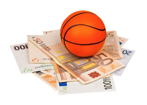 Small basketball ball on heap of euro isolated on a white background