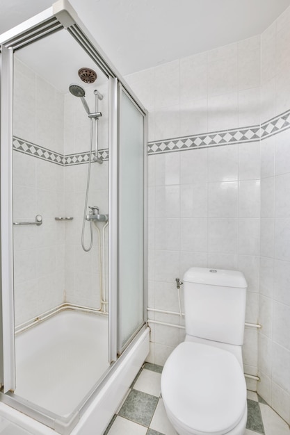 Small bathroom interior with white cabinets, granite countertops and toilet.