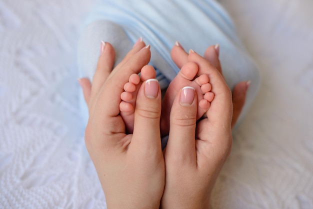 Small beautiful legs of a newborn baby in the first days of life Baby feet of a newborn