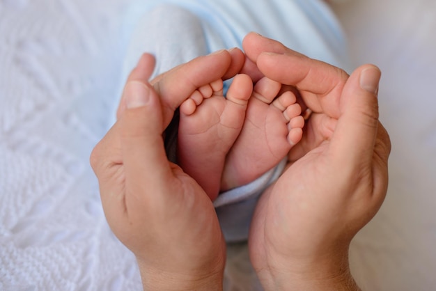 Small beautiful legs of a newborn baby in the first days of life Baby feet of a newborn