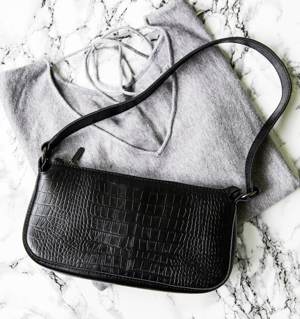 Small black leather bag and gray women's sweater