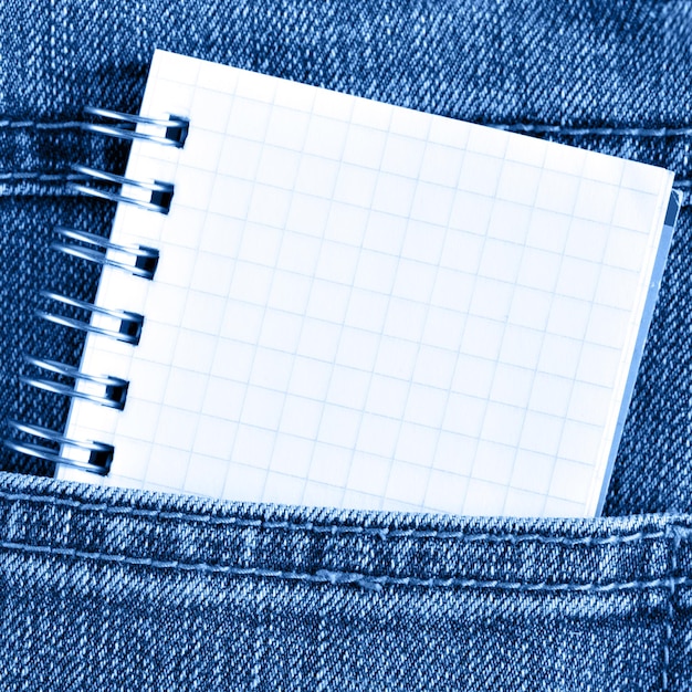 Photo small blank notebook in jeans poket close up