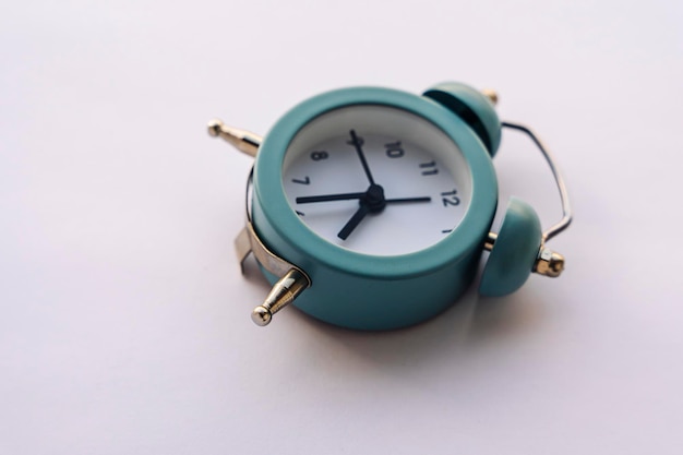 Small blue alarm clock in vintage style on a white background