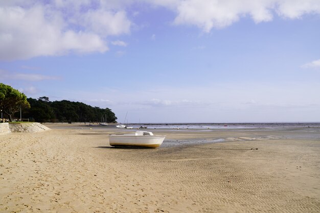 Фото Маленькая лодка на песчаном пляже во время отлива в аресе в аркашон бэй жиронда департамент франция
