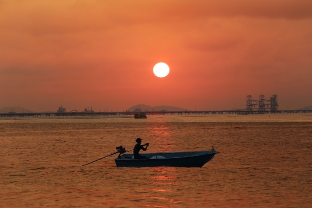 海と夕焼け空を走る小さなボート