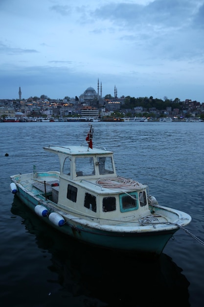 A small boat waiting on the shore of the Golden Horn with the background of Suleymaniye mosque