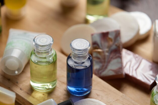 A small bottle of blue liquid sits on a wooden cutting board.