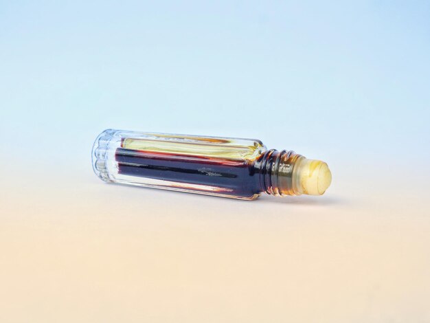 small bottle contains perfume liquid and a white round cap at the end