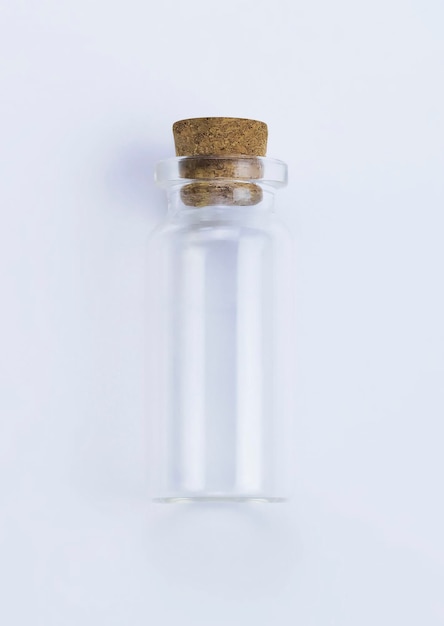 A small bottle of water with a cork cap on it.