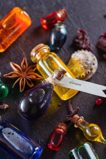 Small bottles with colorful liquids lie on the table among\
various magical attributes.