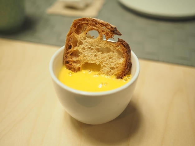 A small bowl of bread with a piece of bread sticking out of it