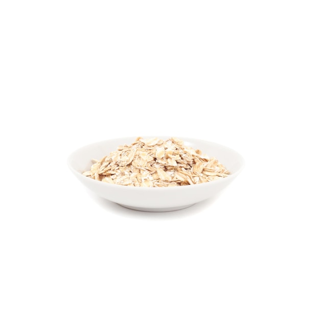 Photo small bowl with oats for breakfast on white background