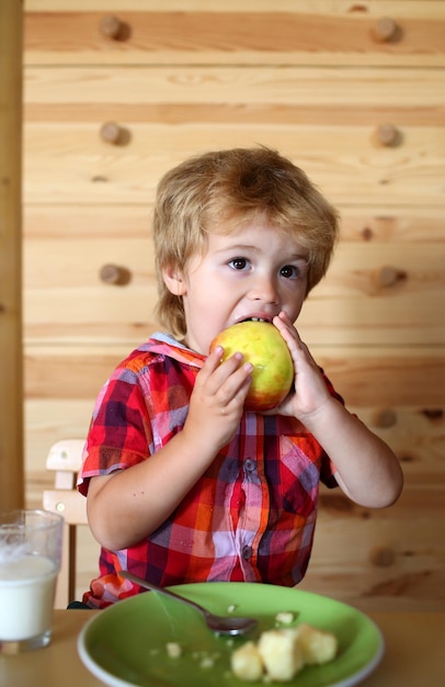 Small boy child eat banana and drink milk.