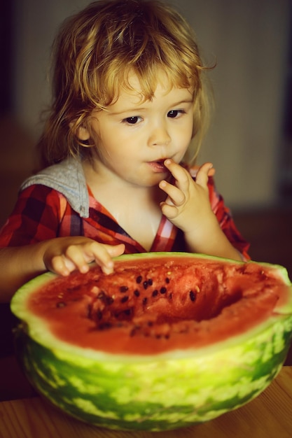 Small boy eating red watermelon